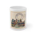 11oz white ceramic mug featuring a vintage postage stamp illustration of the New Orleans skyline in watercolor and ink.
